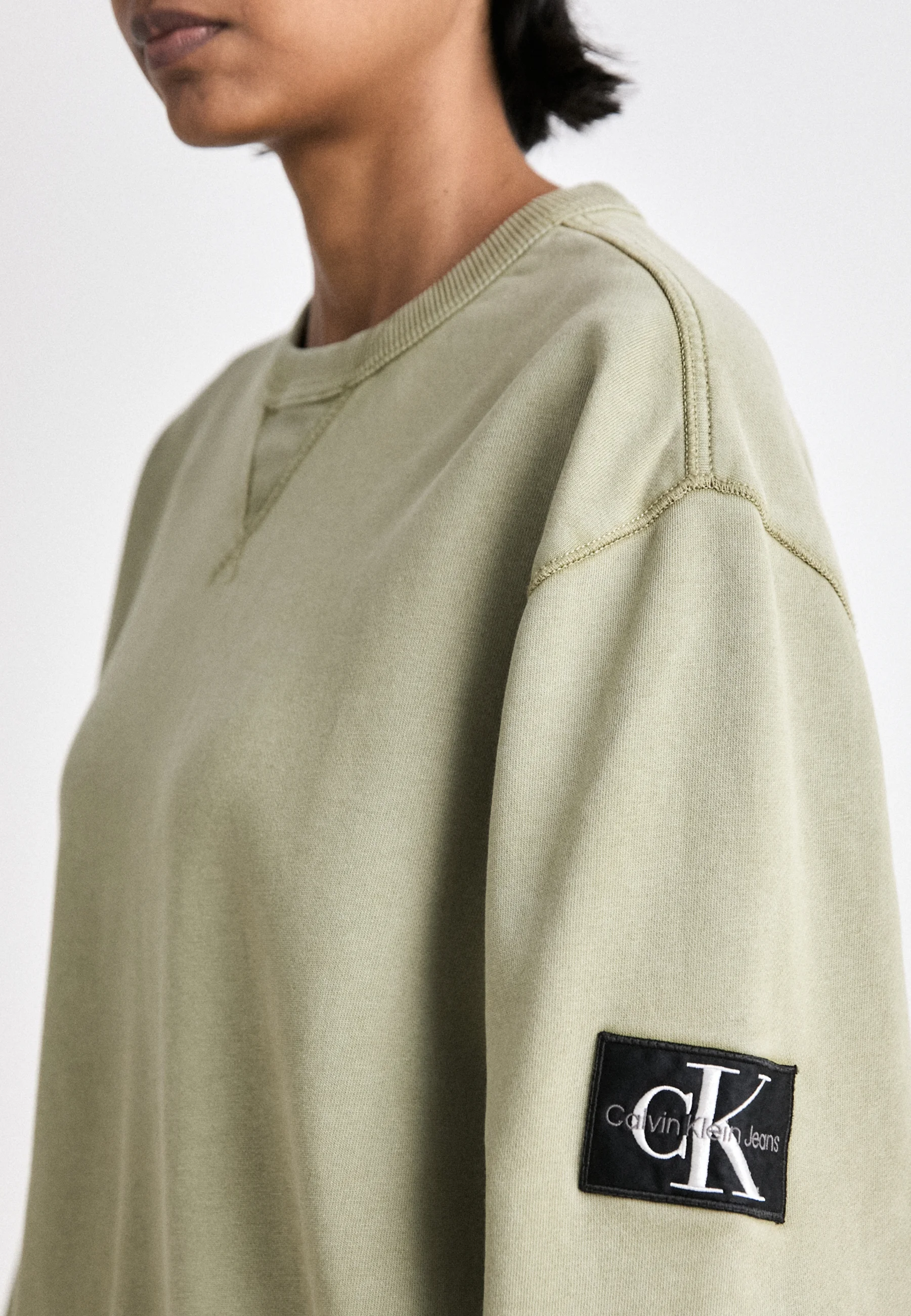 Sudadera unisex de cuello redondo con insignia lavada de Calvin Klein Jeans
