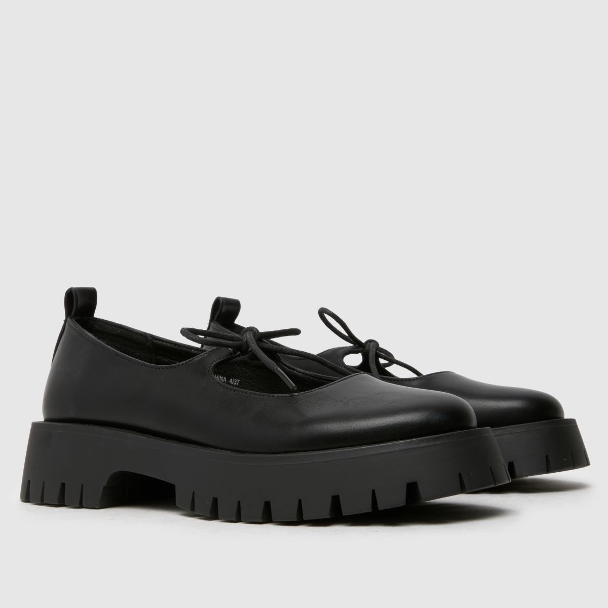 Schuh Liya – Svarta platta skor med fluga och Mary Jane-motiv
