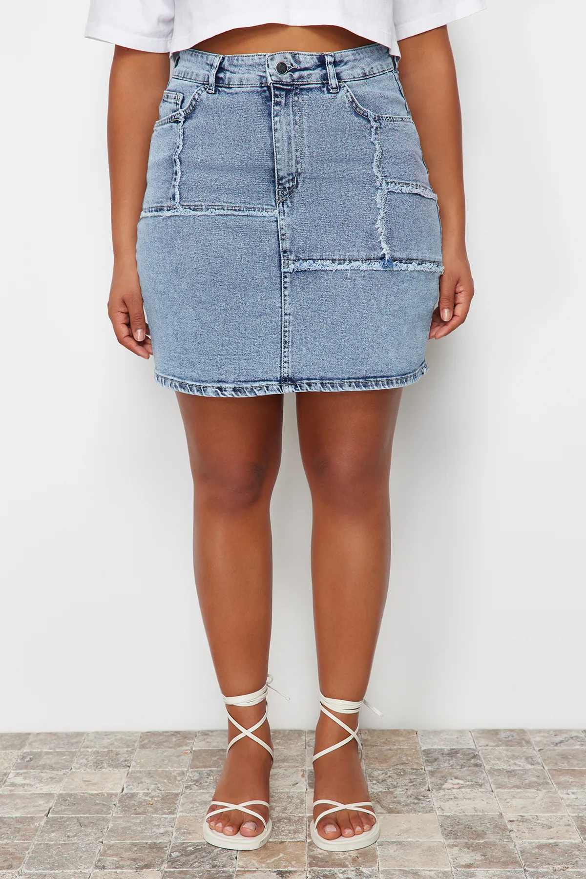Trendyol Curve  Hellblauer Mini-Jeansrock mit Ziernähten und Quasten TBSSS24AZ00018