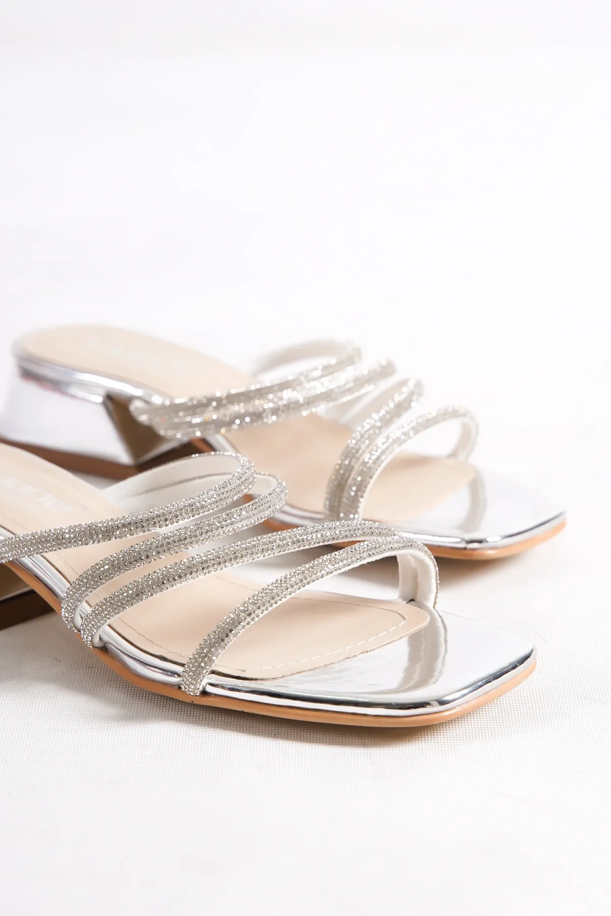 Capone Outfitters  Capone Blunt Toe Stone Banded Damen-Hausschuhe mit kurzem Absatz aus Spiegelstoff in Silber