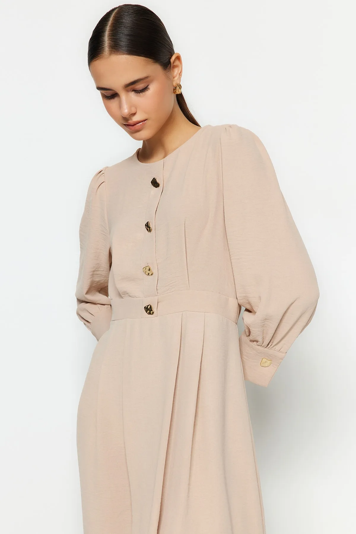 Trendyol Modest  Hellbeige Aerobin-Gewebtes Kleid mit goldenen Knöpfen TCTSS23EB00361