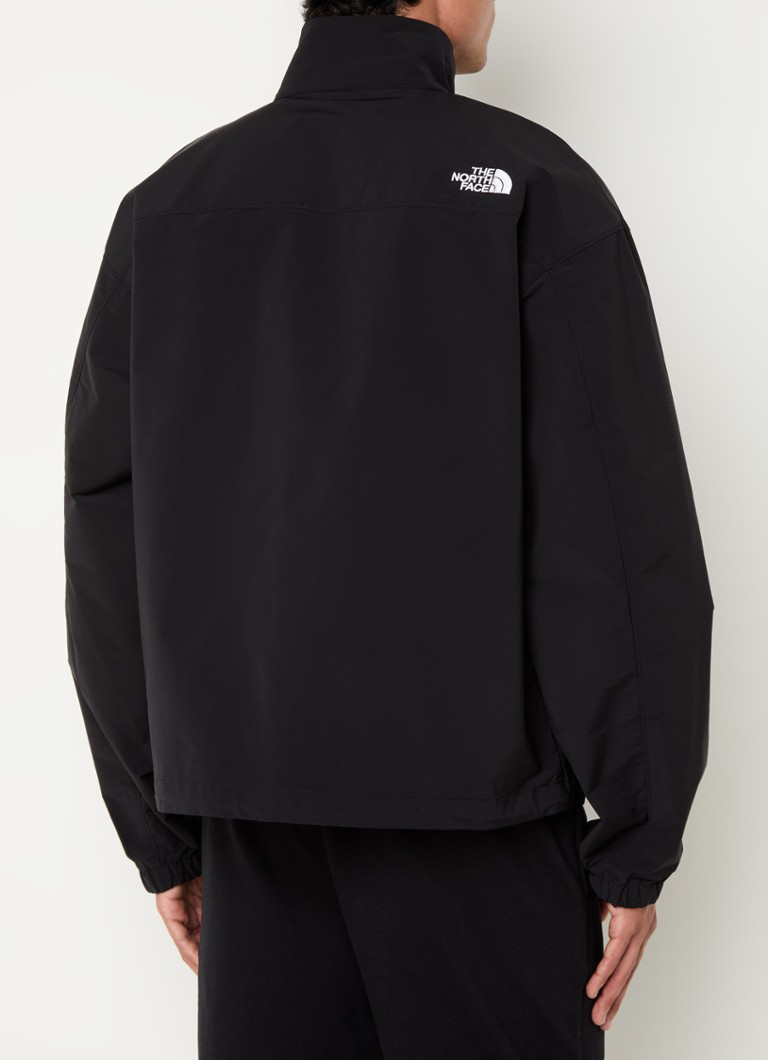 Jachetă impermeabilă cu logo-ul The North Face și buzunare cu fermoar.