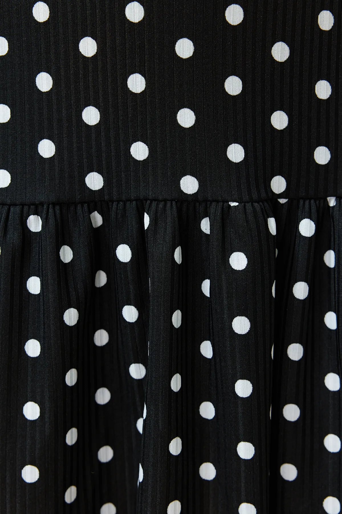 Trendyol Curve  Schwarzes, gepunktetes, ärmelloses, gerade geschnittenes Mini-Stretch-Strickkleid mit Volants TBSSS24AH00131
