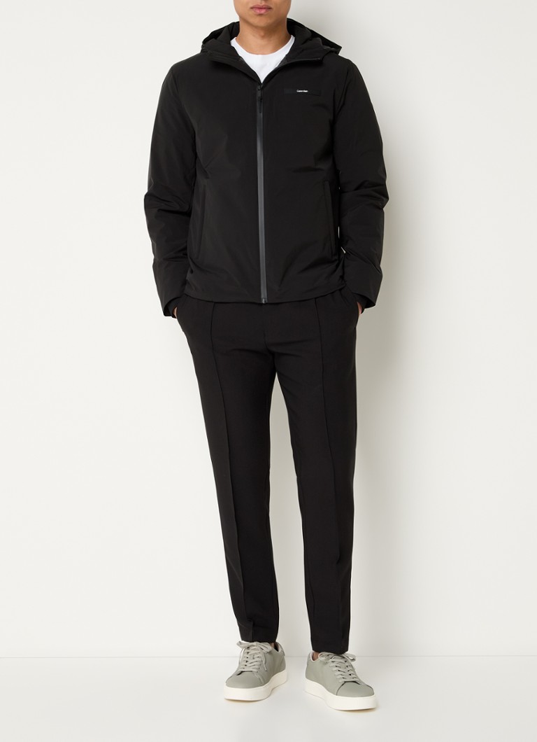 Jachetă softshell Calvin Klein cu glugă și buzunare cu fermoar.