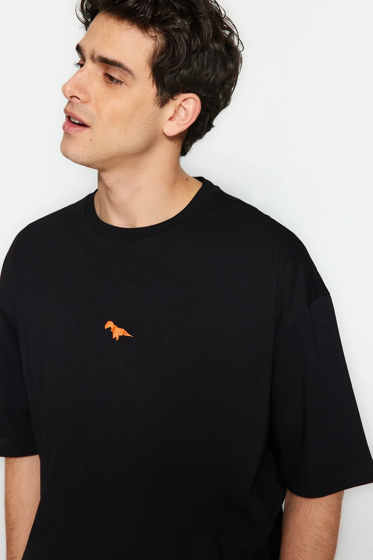 Trendyol Collection  Schwarzes Oversize-Fit-T-Shirt mit Rundhalsausschnitt und kurzen Ärmeln aus 100 % Baumwolle mit Dinosaurier-Stickerei TMNSS23TS00243