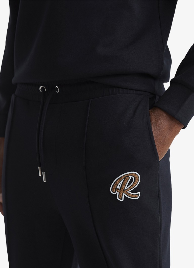 Pantaloni de trening conici Reiss Premier cu buzunare laterale.