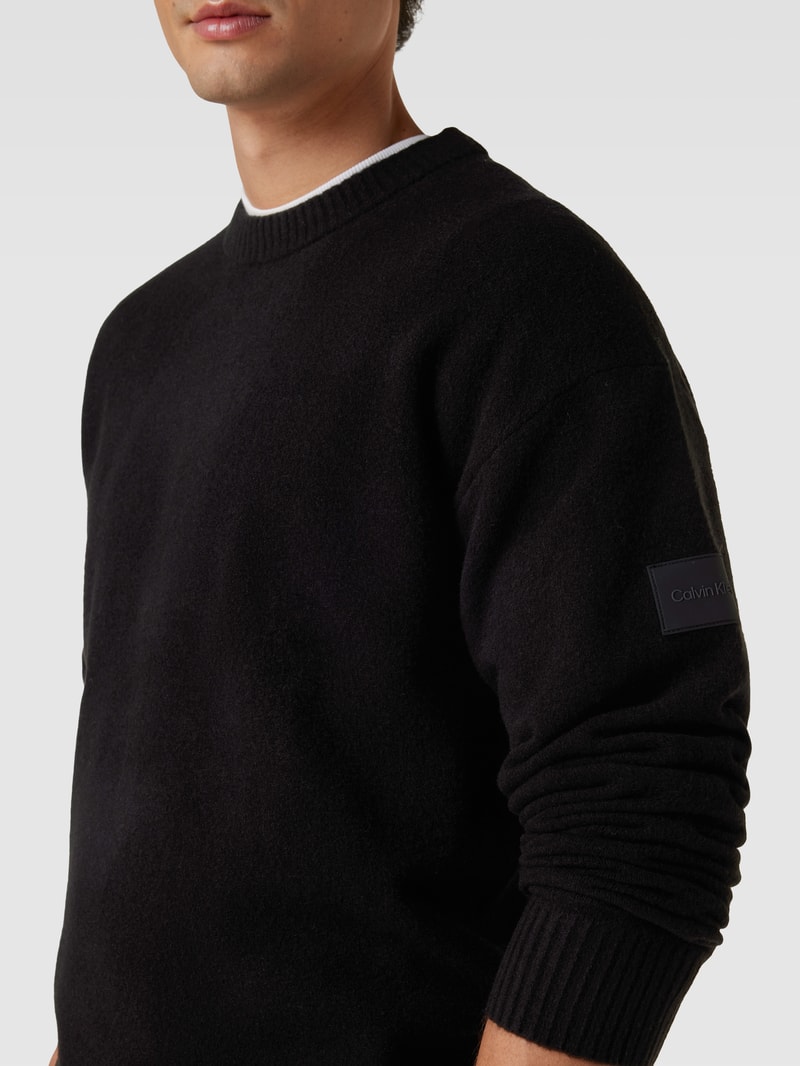 Strickpullover mit Label-Patch Modell 'LYCRA' in schwarz