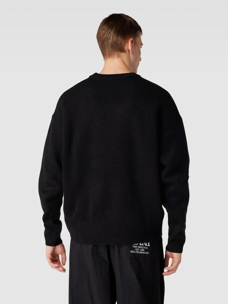 Strickpullover mit Label-Patch und überschnittenen Schultern in schwarz