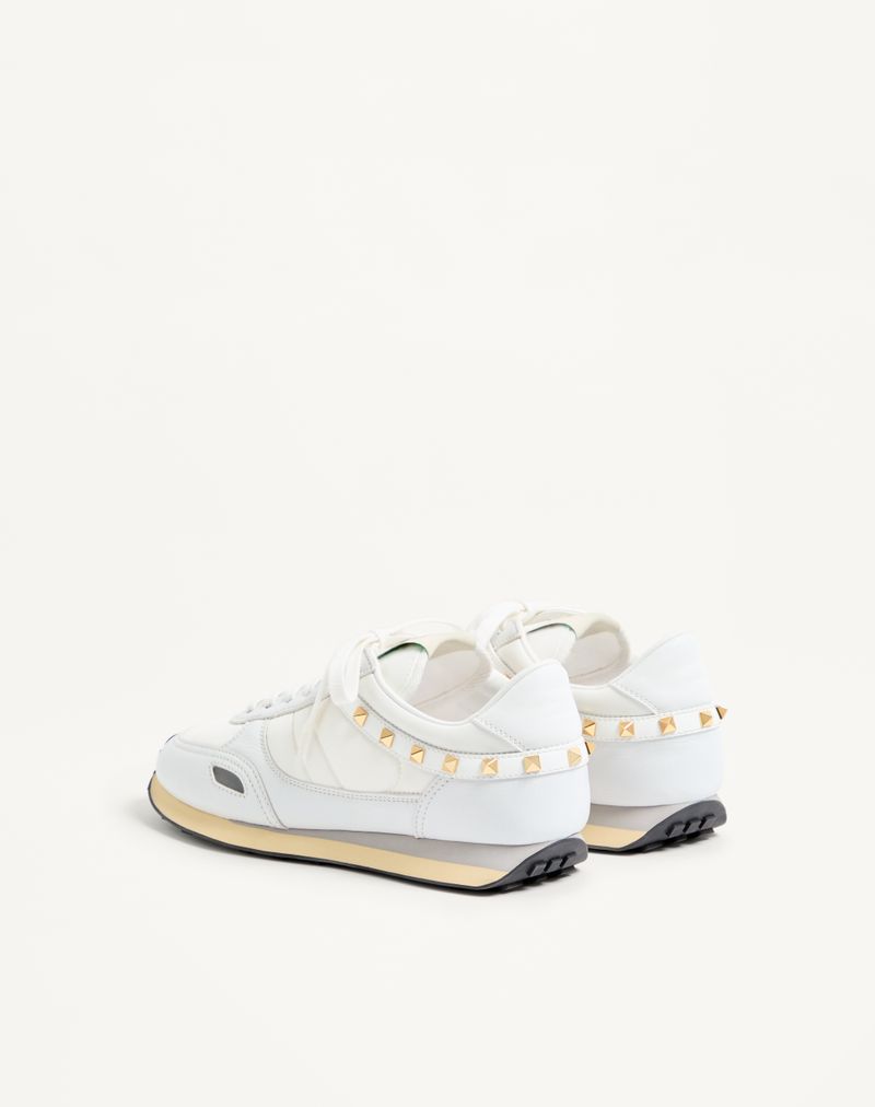 Tênis com tachas em couro e nylon.