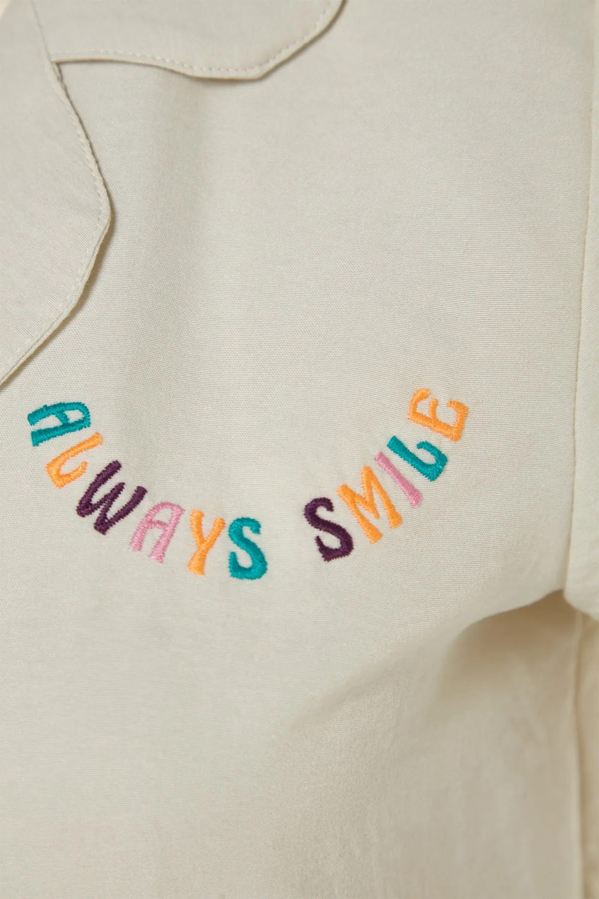 Trendyol Collection  Hellbeigefarbenes Pyjama-Set aus Hemd und Shorts mit aufgesticktem Slogan THMSS23PT00232