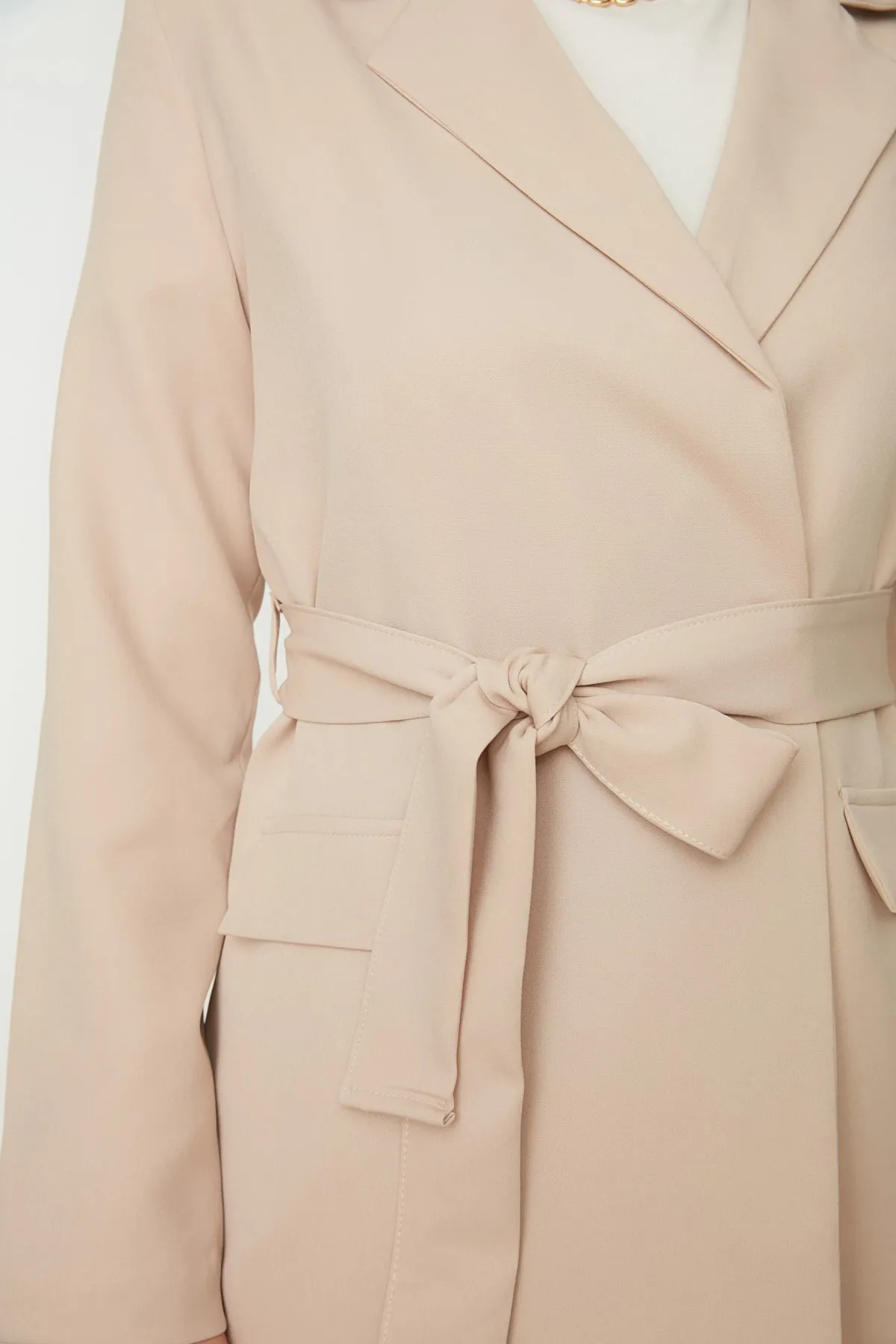 Trendyol Modest  Beigefarbene, gewebte Blazer-Jacke mit Taschendetail und Gürtel TCTAW22CK0031