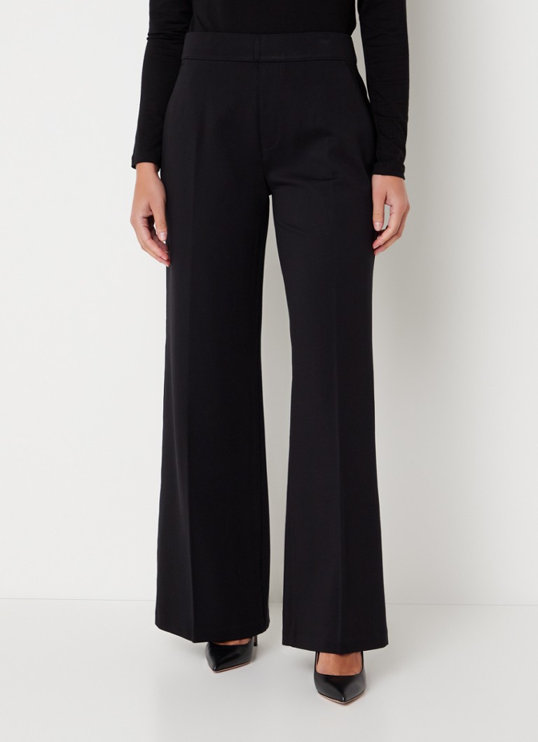 Calças SPANX de cintura alta e corte flare, confeccionadas em malha com costura divisória.
