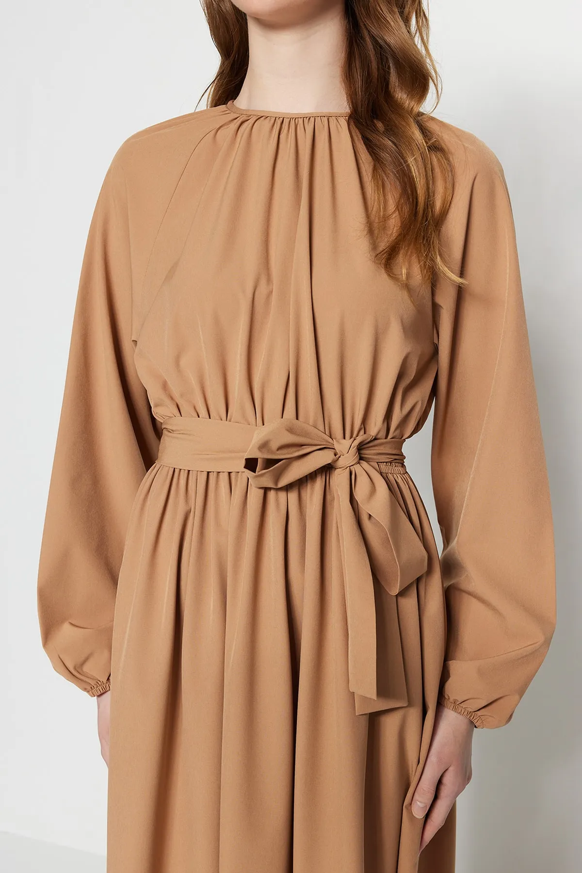 Trendyol Modest  Kamelfarbenes, gewebtes Kleid aus Fallschirmstoff mit Gürtel und Raffung in weiter Passform TCTSS23EB00253
