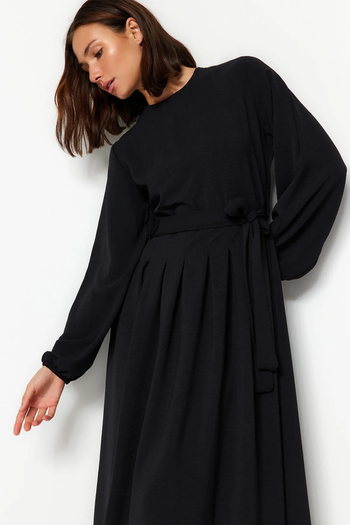 Trendyol Modest  Schwarzes, plissiertes Aerobin-Gewebekleid mit Gürtel TCTAW24EB00043