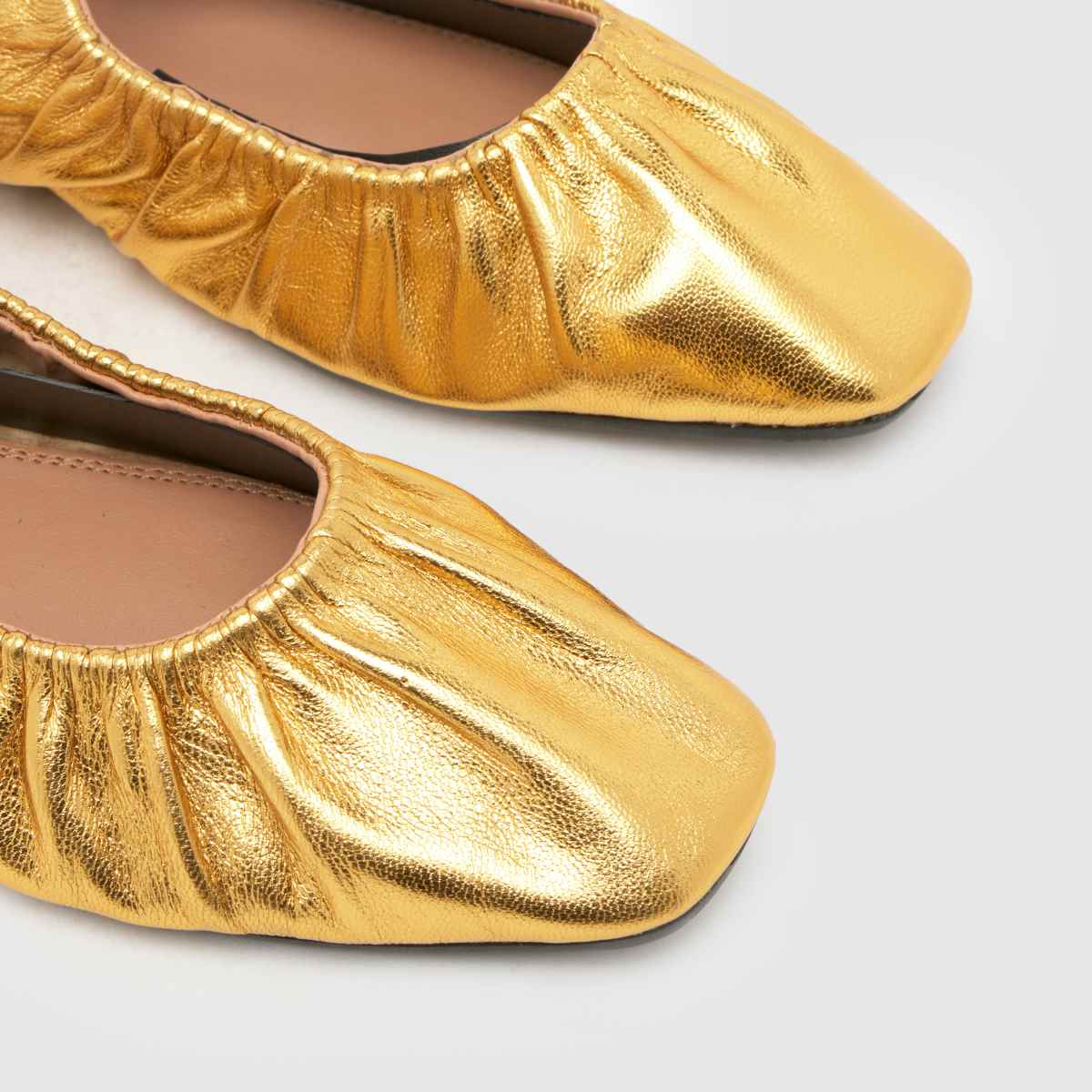 Schuh Lindy – Guldfärgade ballerinaskor i läder med rynka detaljer