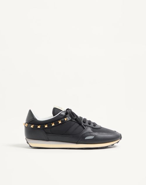 Tênis com tachas em couro e nylon.