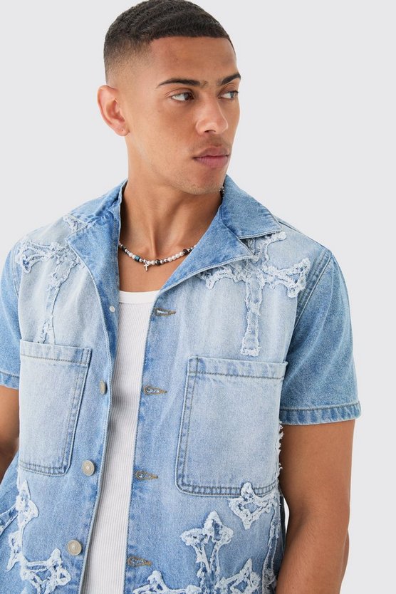 Zerrissenes hellblaues Jeanshemd mit Kreuz-Applikation