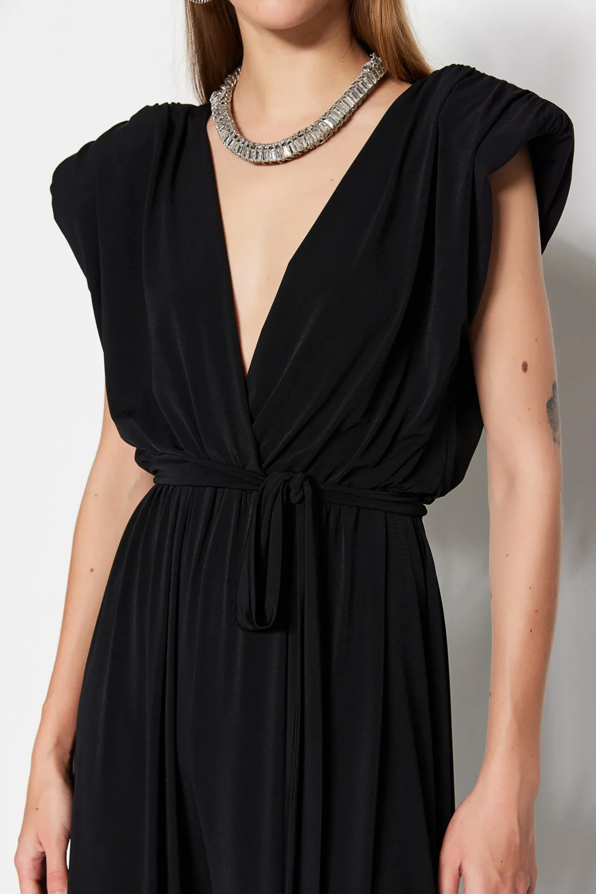 Trendyol Collection  Schwarzer Strick-Jumpsuit mit V-Ausschnitt und Gürtel TPRSS23TU00029