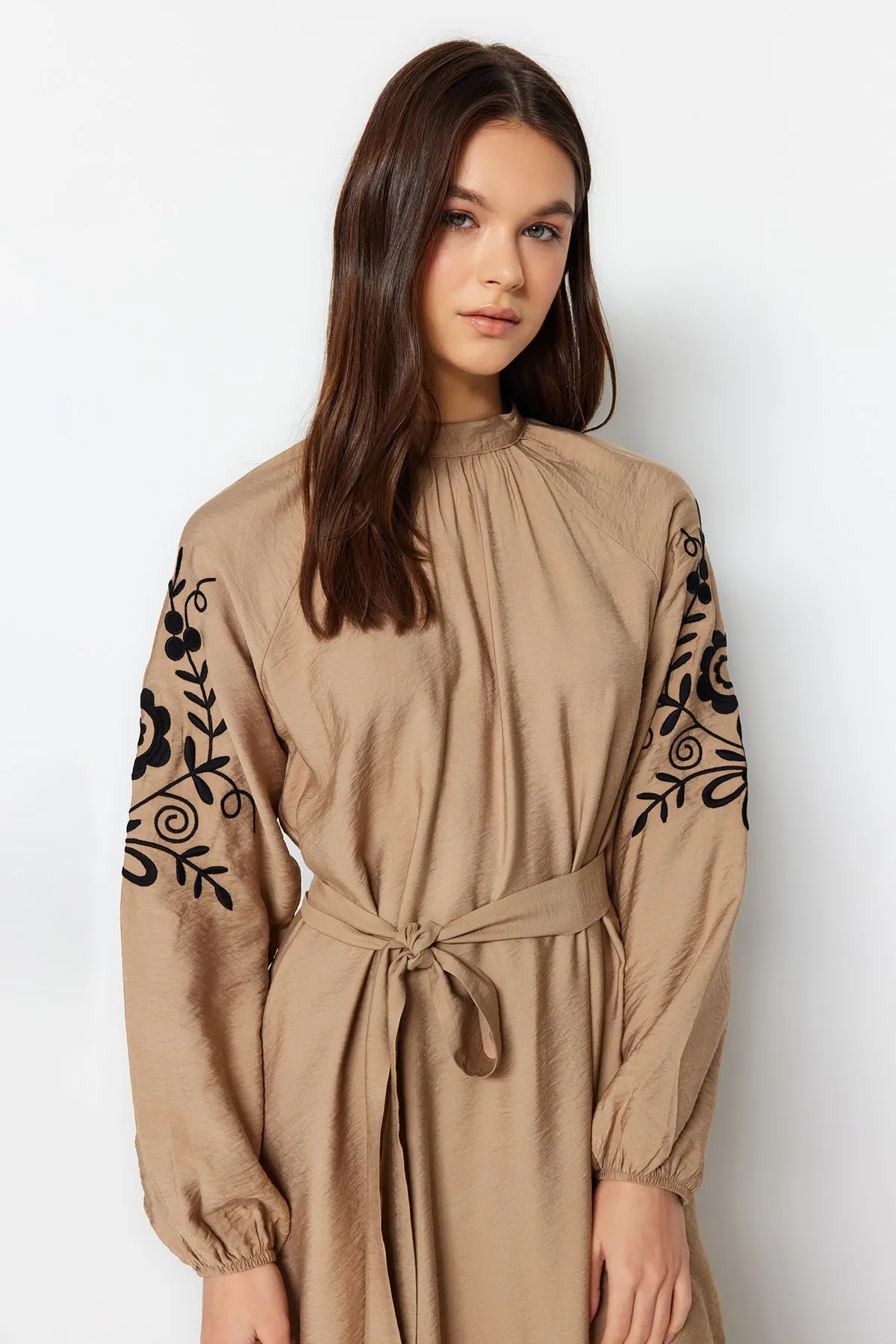 Trendyol Modest  Beigefarbenes Kleid mit Gürtelstickerei, weitem Schnitt und gewebter Leinenoptik TCTSS23EB00224