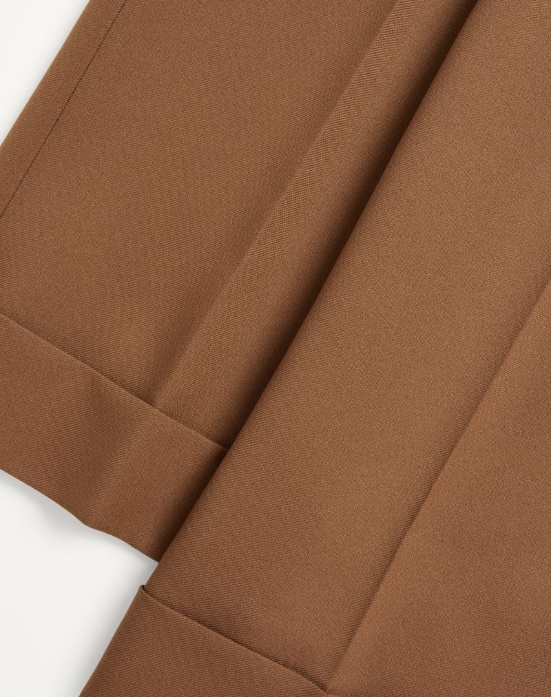 Calças de gabardine de nylon com bainha dobrada.