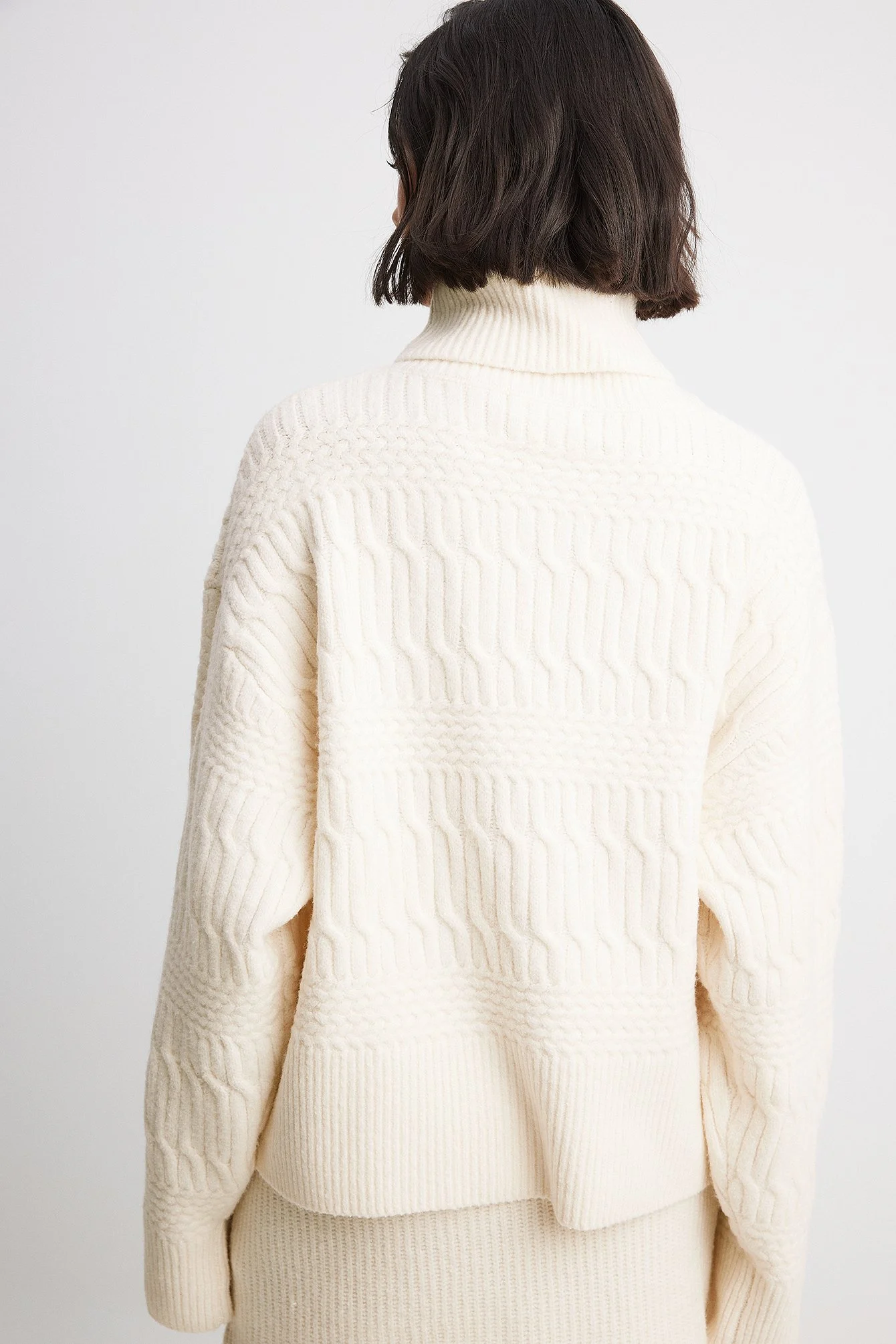 Hochgeschlossener Strickpullover mit Zopfmuster