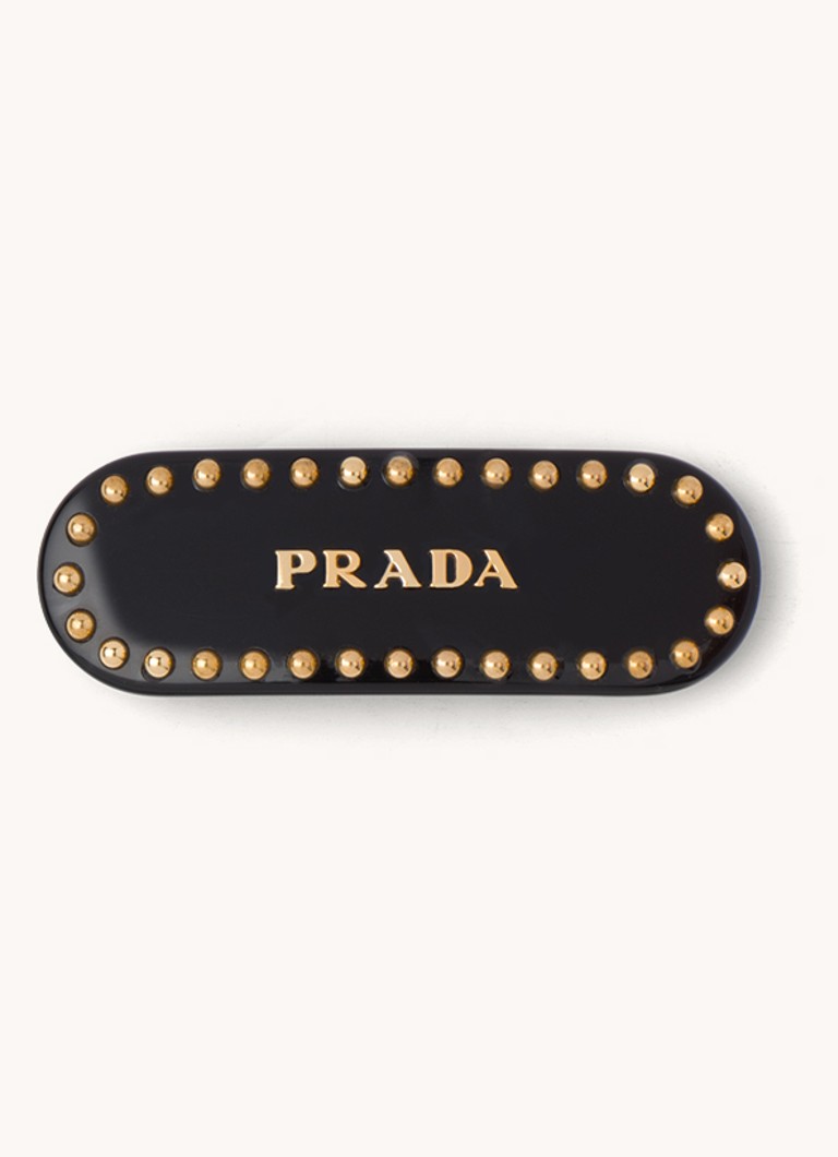 Pradan hiuspinni logolla ja niiteillä