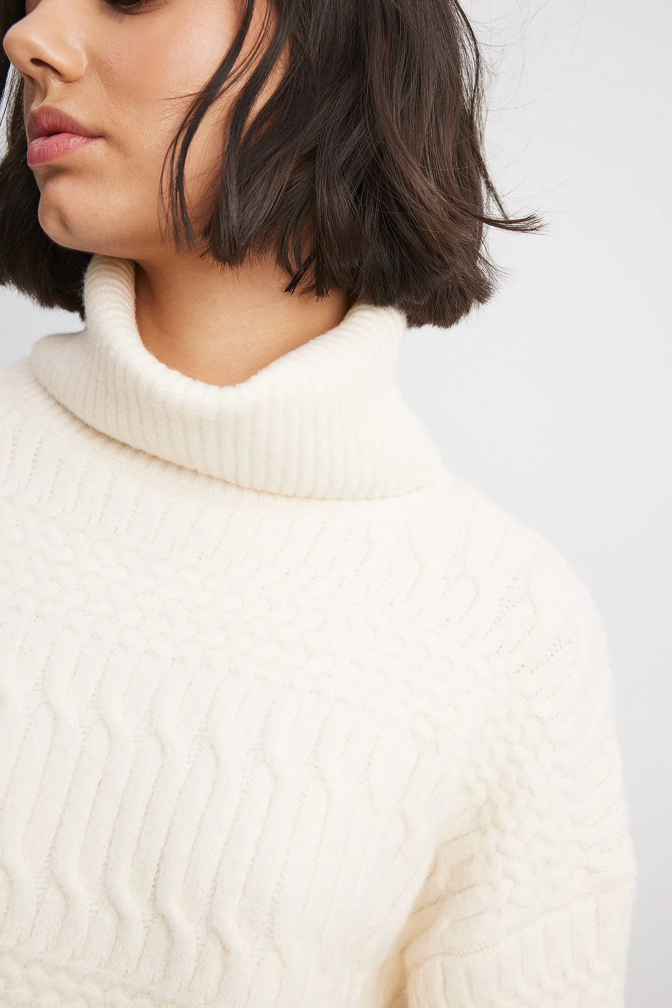 Hochgeschlossener Strickpullover mit Zopfmuster