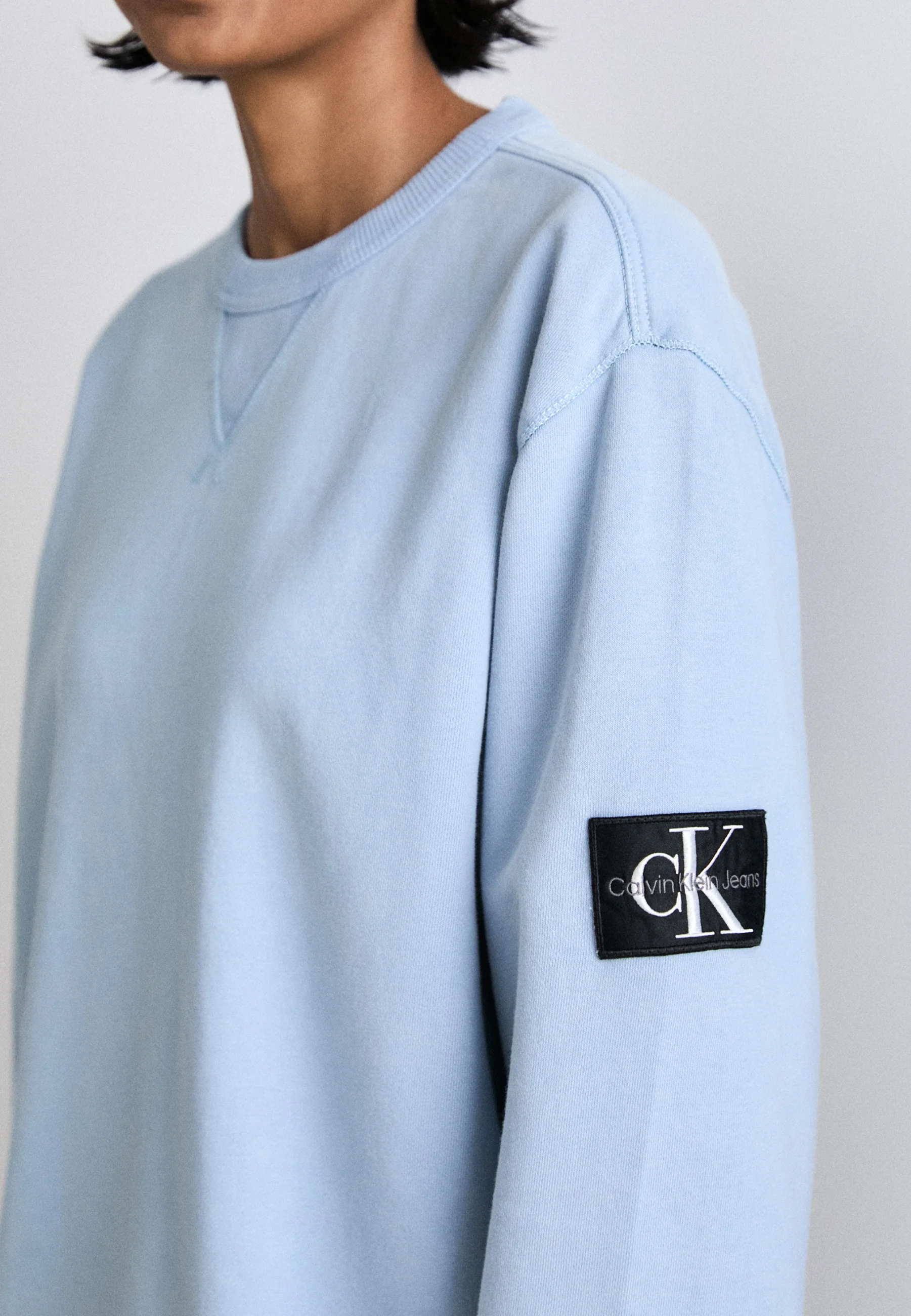 Sudadera unisex de cuello redondo con insignia lavada de Calvin Klein Jeans