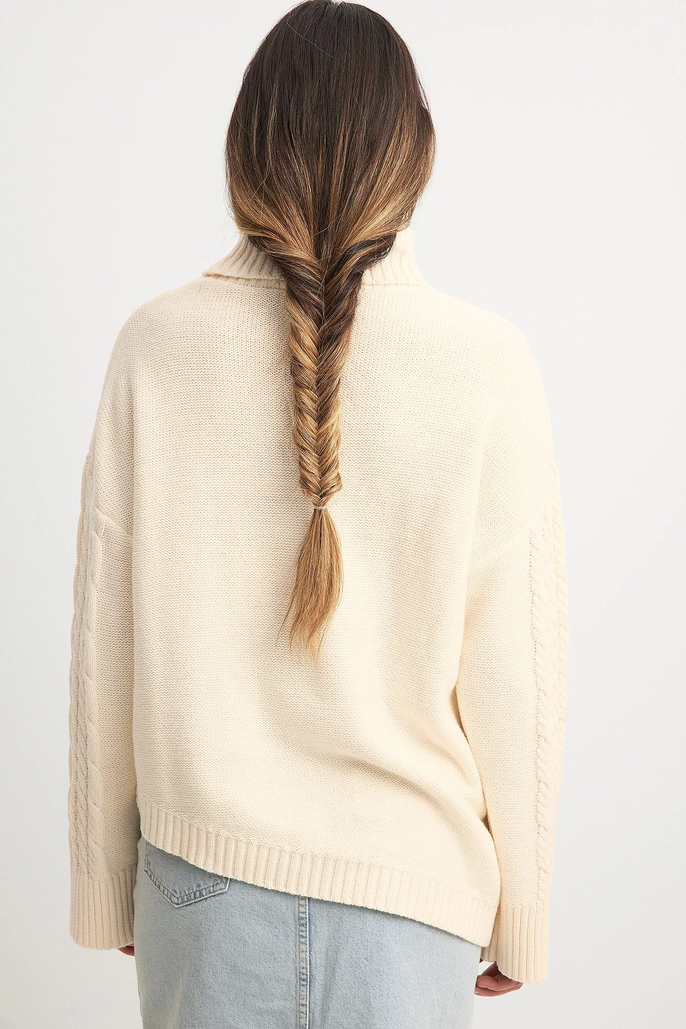 Asymmetrischer Strickpullover mit Zopfmuster