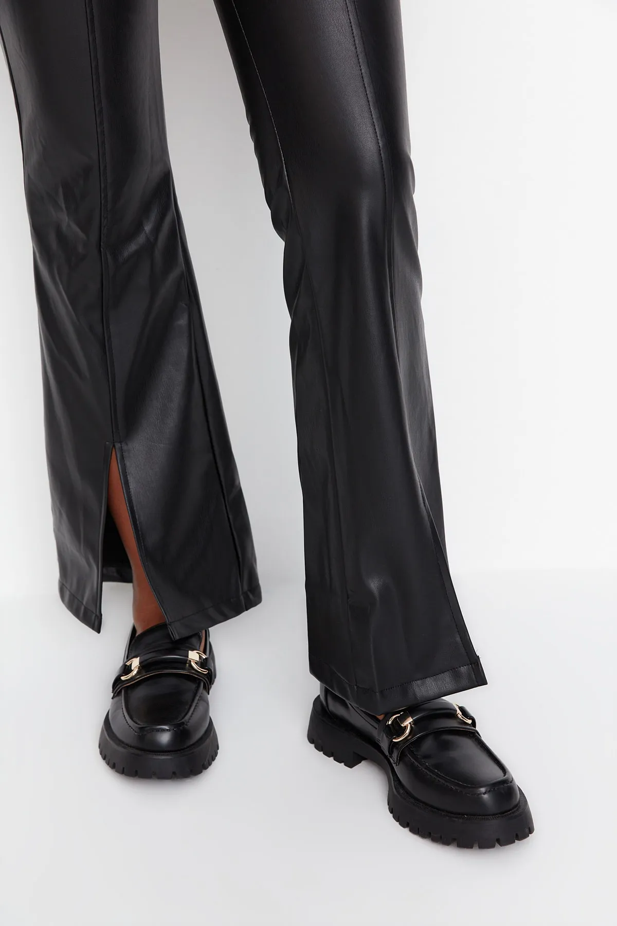 Trendyol Collection  Schwarze Hose aus gewebtem Kunstleder mit ausgestelltem Bein und Schlitzdetail TWOAW23PL00056