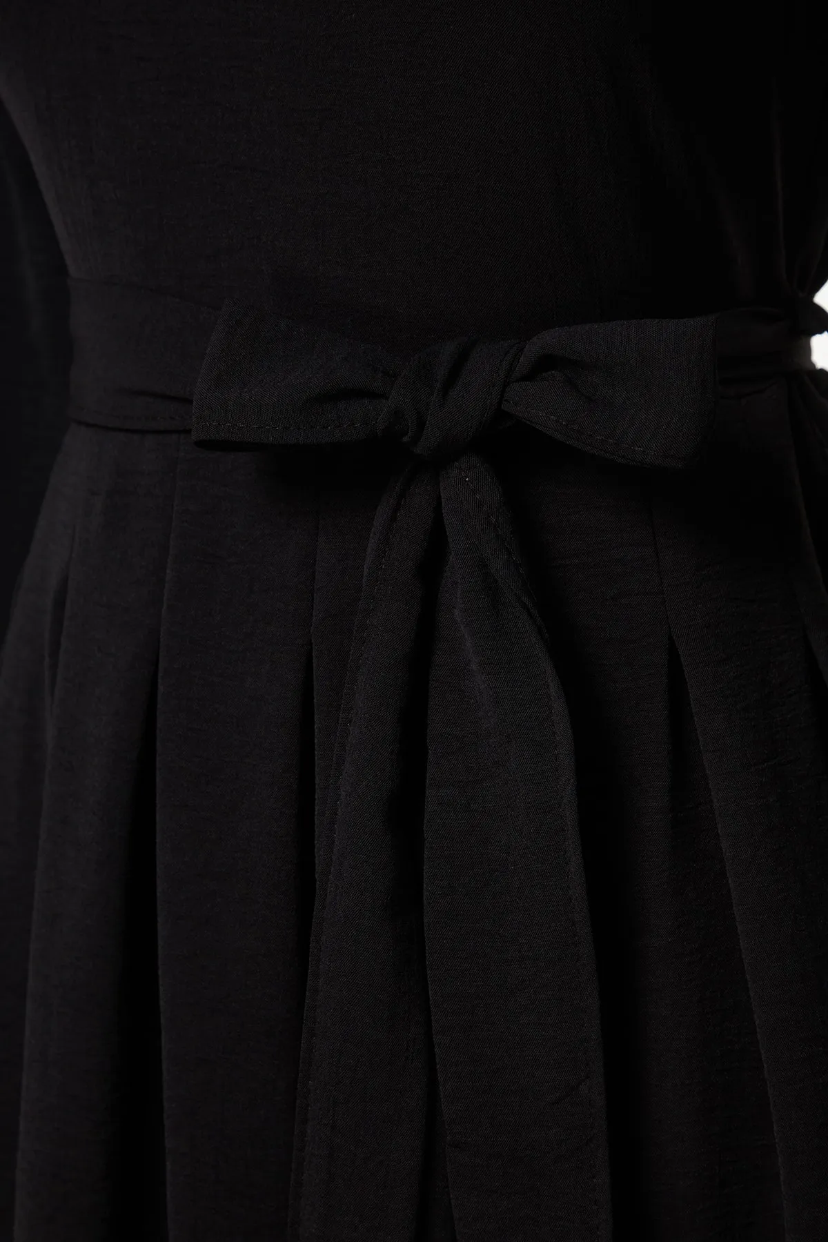 Trendyol Modest  Schwarzes, plissiertes Aerobin-Gewebekleid mit Gürtel TCTAW24EB00043
