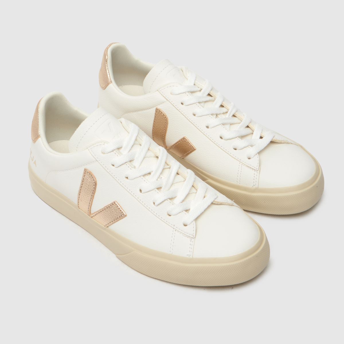Se fältsneakers i vitt och guld.