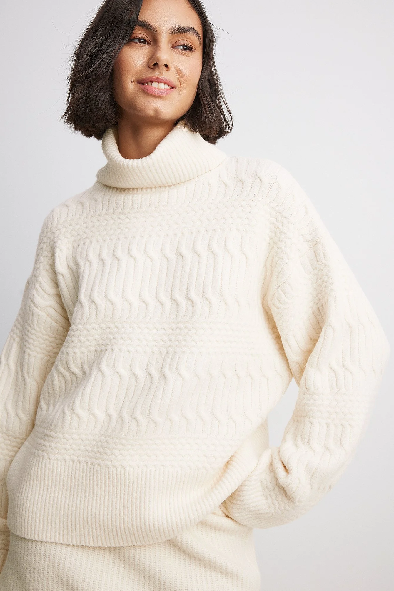 Hochgeschlossener Strickpullover mit Zopfmuster