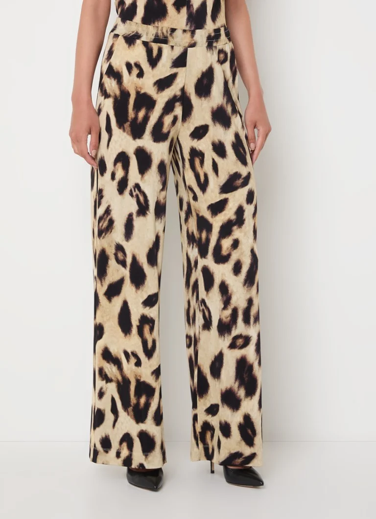 Pantalonii cu talie înaltă și croială largă, de la Claudia Sträter, prezintă un imprimeu leopard și buzunare laterale.