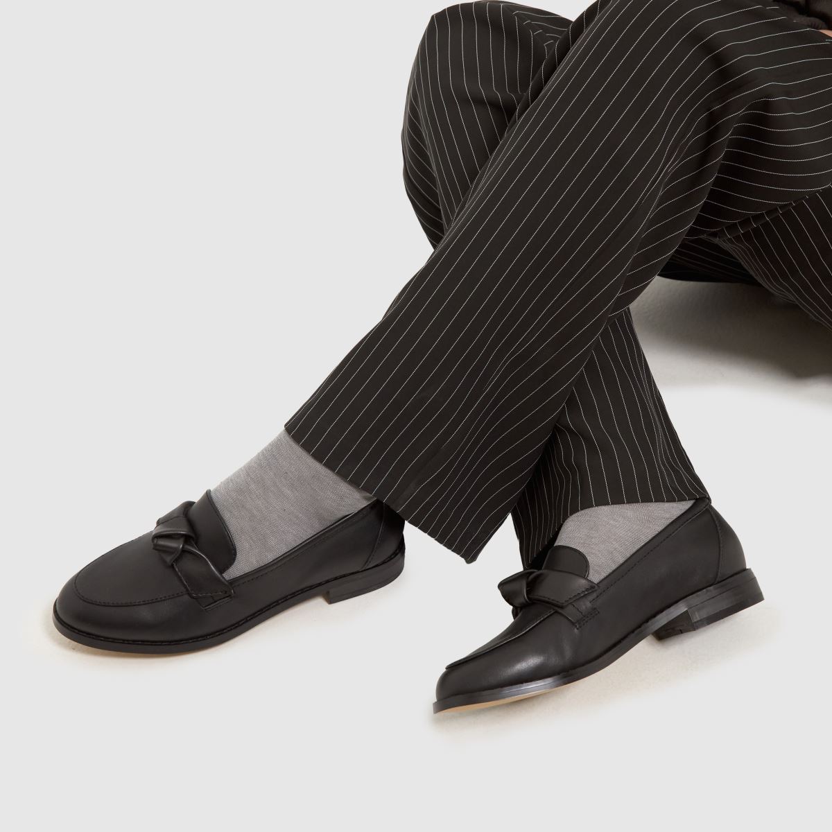 Schuh – Lula – Svarta, platta loafers i läder med rosett