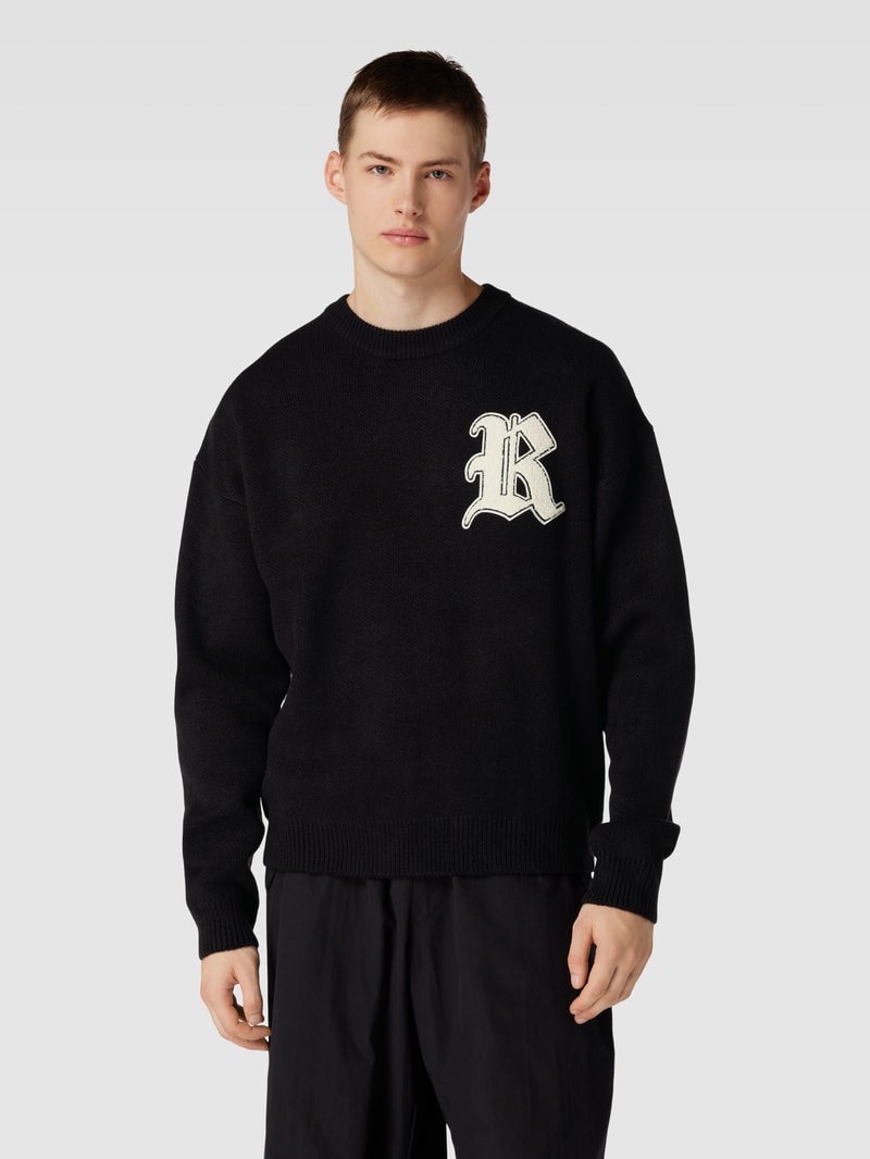 Strickpullover mit Label-Patch und überschnittenen Schultern in schwarz