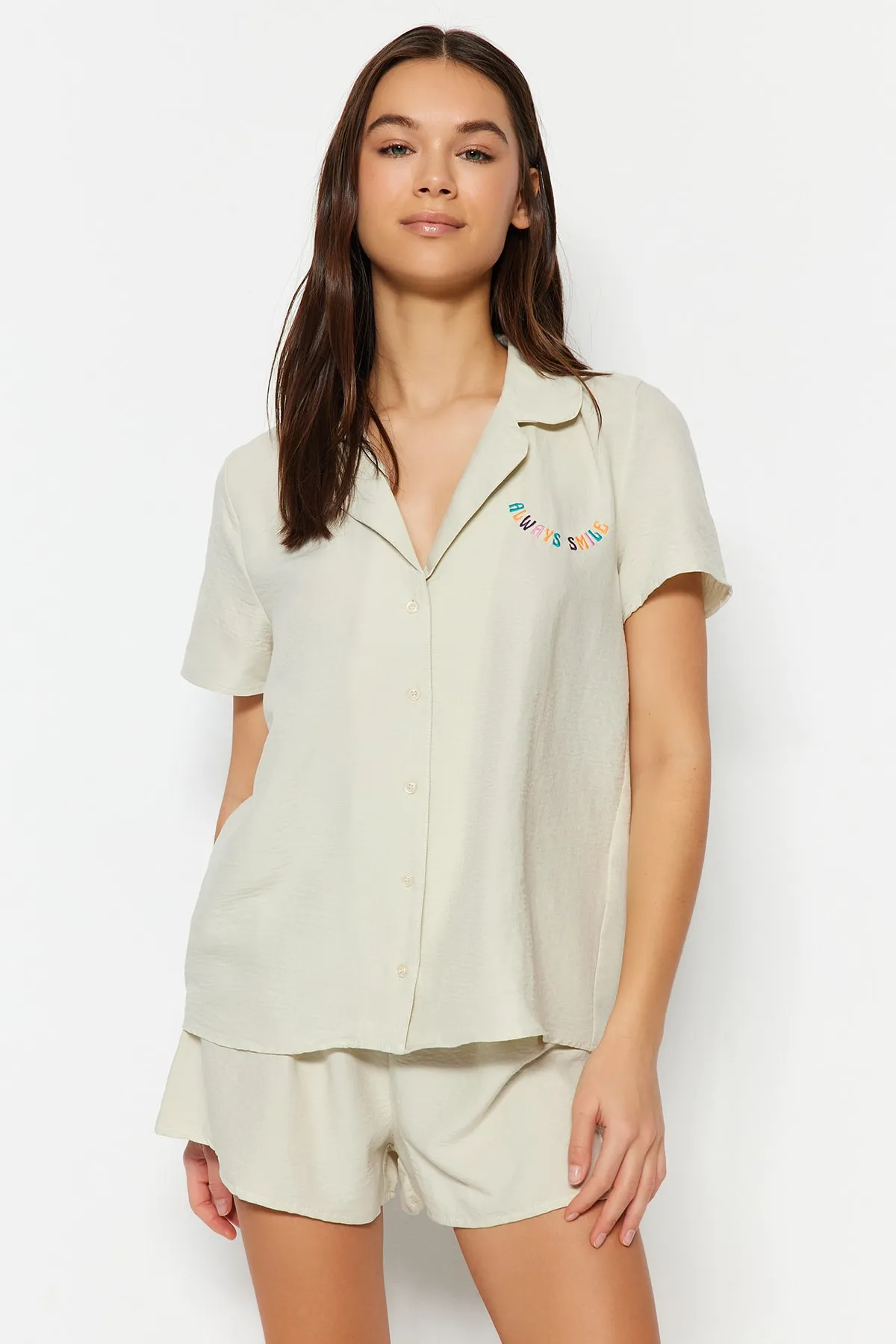 Trendyol Collection  Hellbeigefarbenes Pyjama-Set aus Hemd und Shorts mit aufgesticktem Slogan THMSS23PT00232