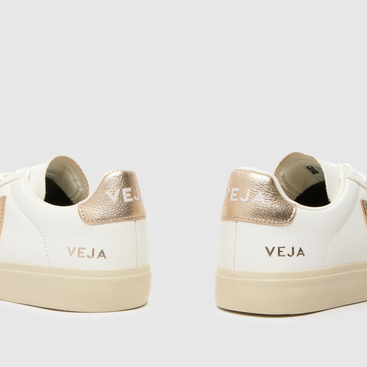 Se fältsneakers i vitt och guld.