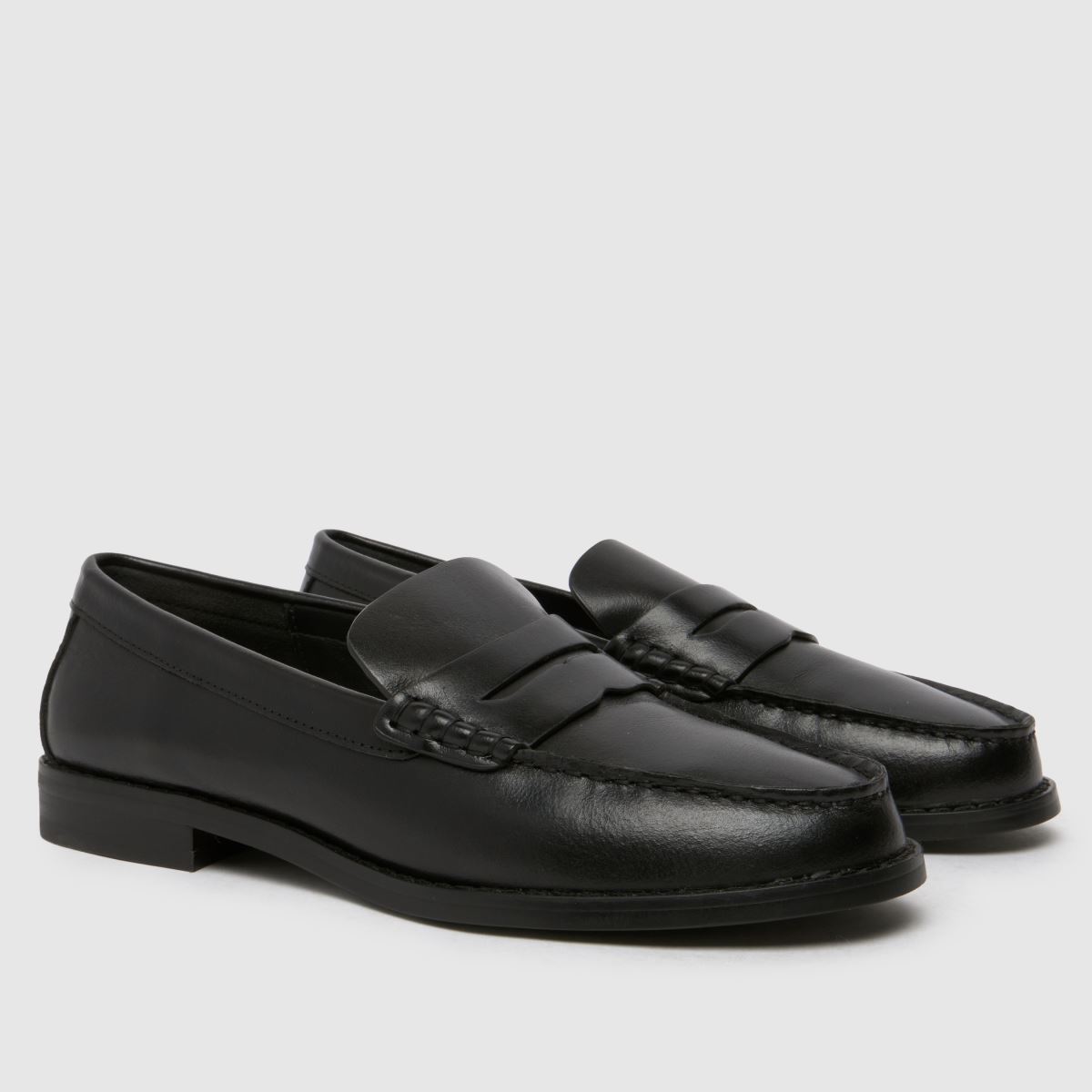 Schuh Lillian – Svarta, platta penny loafers i läder med rem