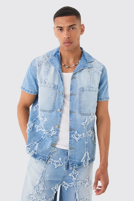 Zerrissenes hellblaues Jeanshemd mit Kreuz-Applikation