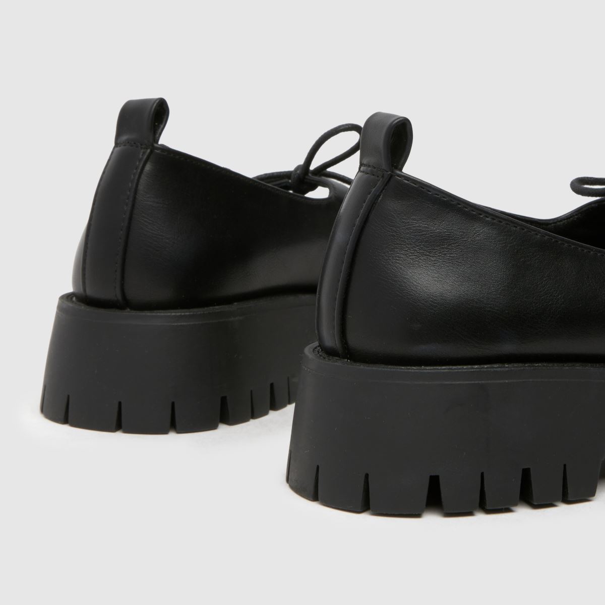Schuh Liya – Svarta platta skor med fluga och Mary Jane-motiv