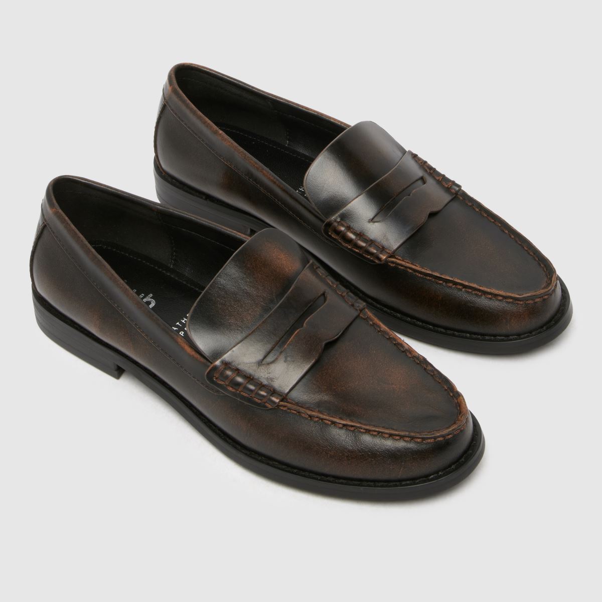 Schuh Lillian – Bruna, platta penny loafers i läder med rem