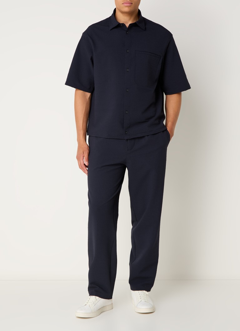 Pantaloni chino până la gleznă de la Emporio Armani, cu croială lejeră și mulată și buzunare laterale.