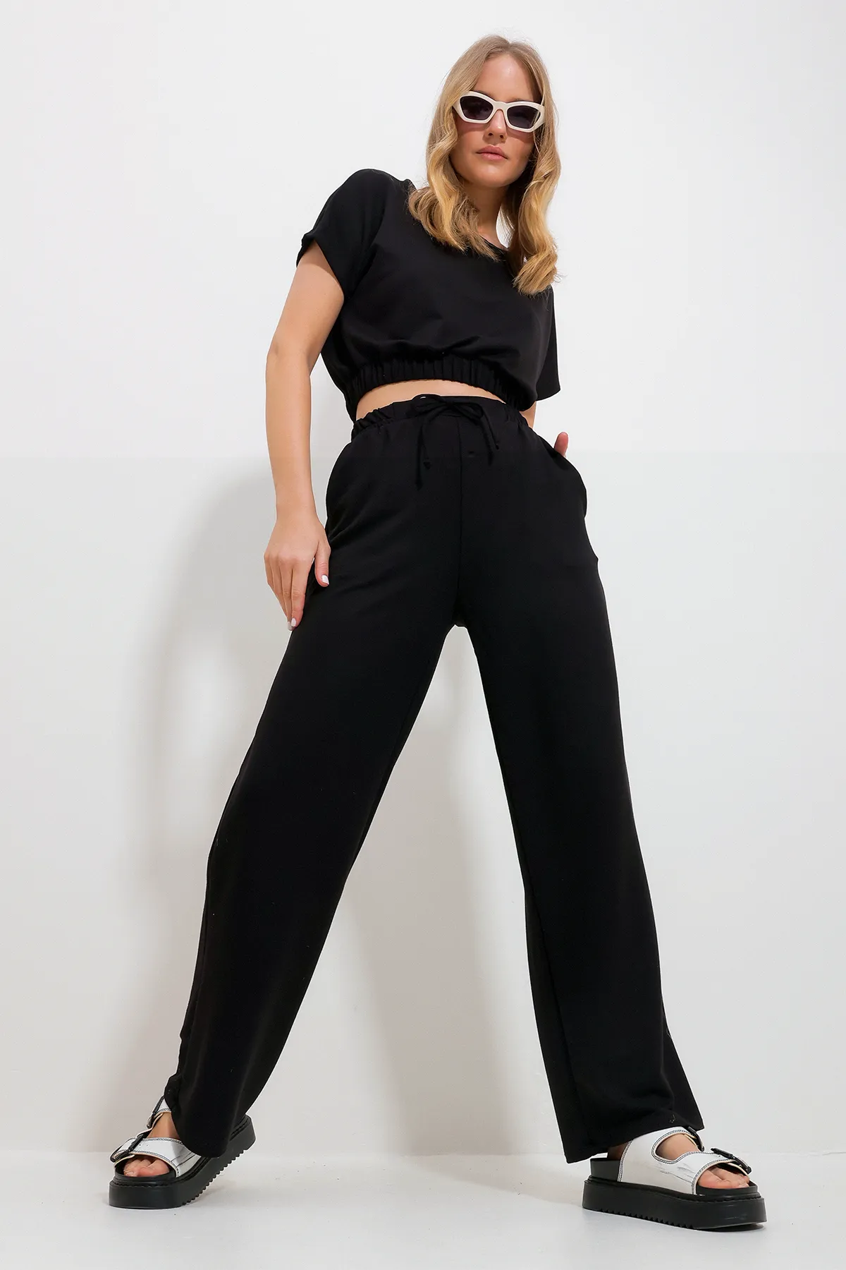 Trend Alaçatı Stili  Schwarzes Damen-Doppelset mit kurzer Bluse und Palazzo-Hose mit Rundhalsausschnitt und zwei TaschenALC-X11895