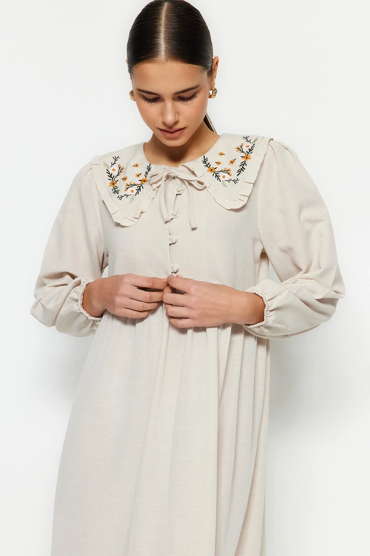 Trendyol Modest  Cremefarbenes, gewebtes Kleid mit halber Knopfleiste und besticktem Kragen in Leinenoptik TCTSS23EB00257