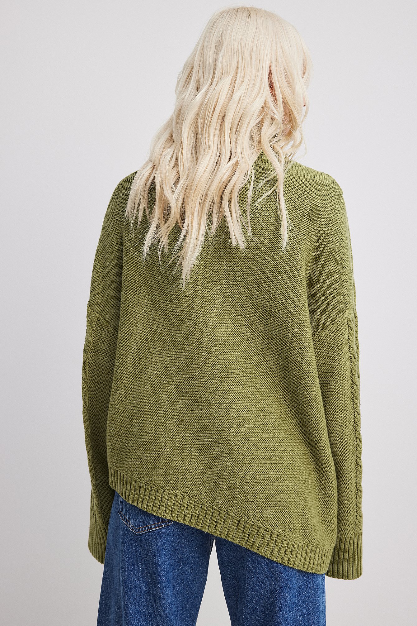 Asymmetrischer Strickpullover mit Zopfmuster