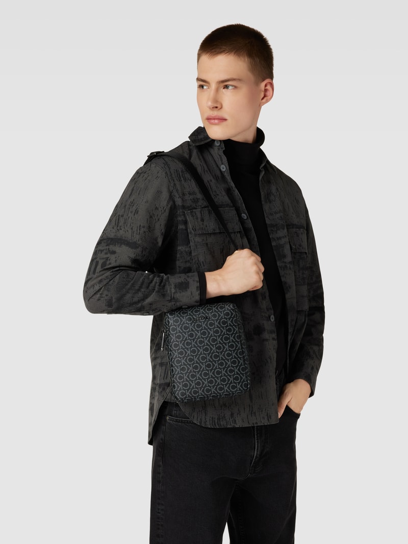 Umhängetasche mit Allover-Label-Details Modell 'MUST' in schwarz