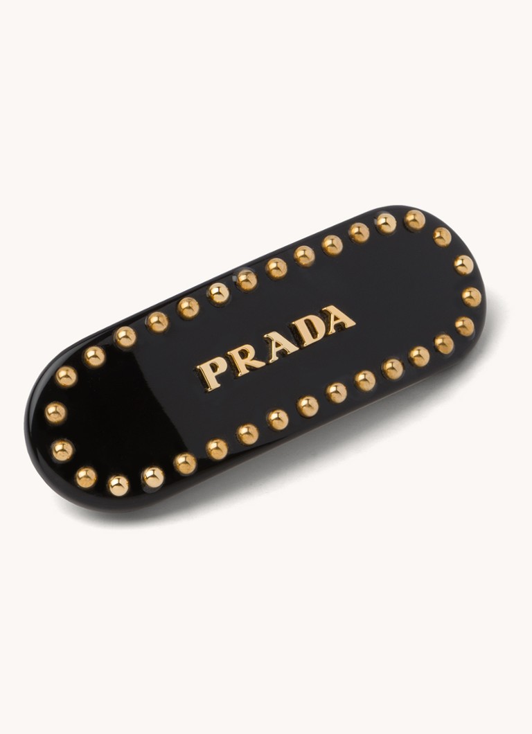 Pradan hiuspinni logolla ja niiteillä