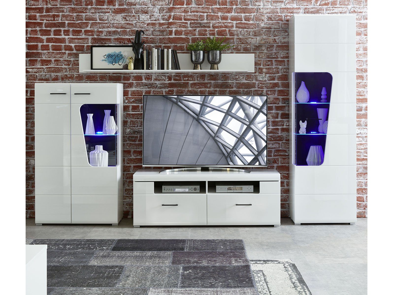 möbelando Wohnwand Filmer, Moderne Wohnwand, Korpus aus Spanplatte in Weiß matt, Front aus MDF in Weiß Hochglanz, Absetzungen in Schwarz bestehend aus 1 Vitrine klein, 1 Vitrine groß, 1 TV-Unterteil und 1 Wandboard, inkl. LED-Beleuchtung. Stellmaß ca