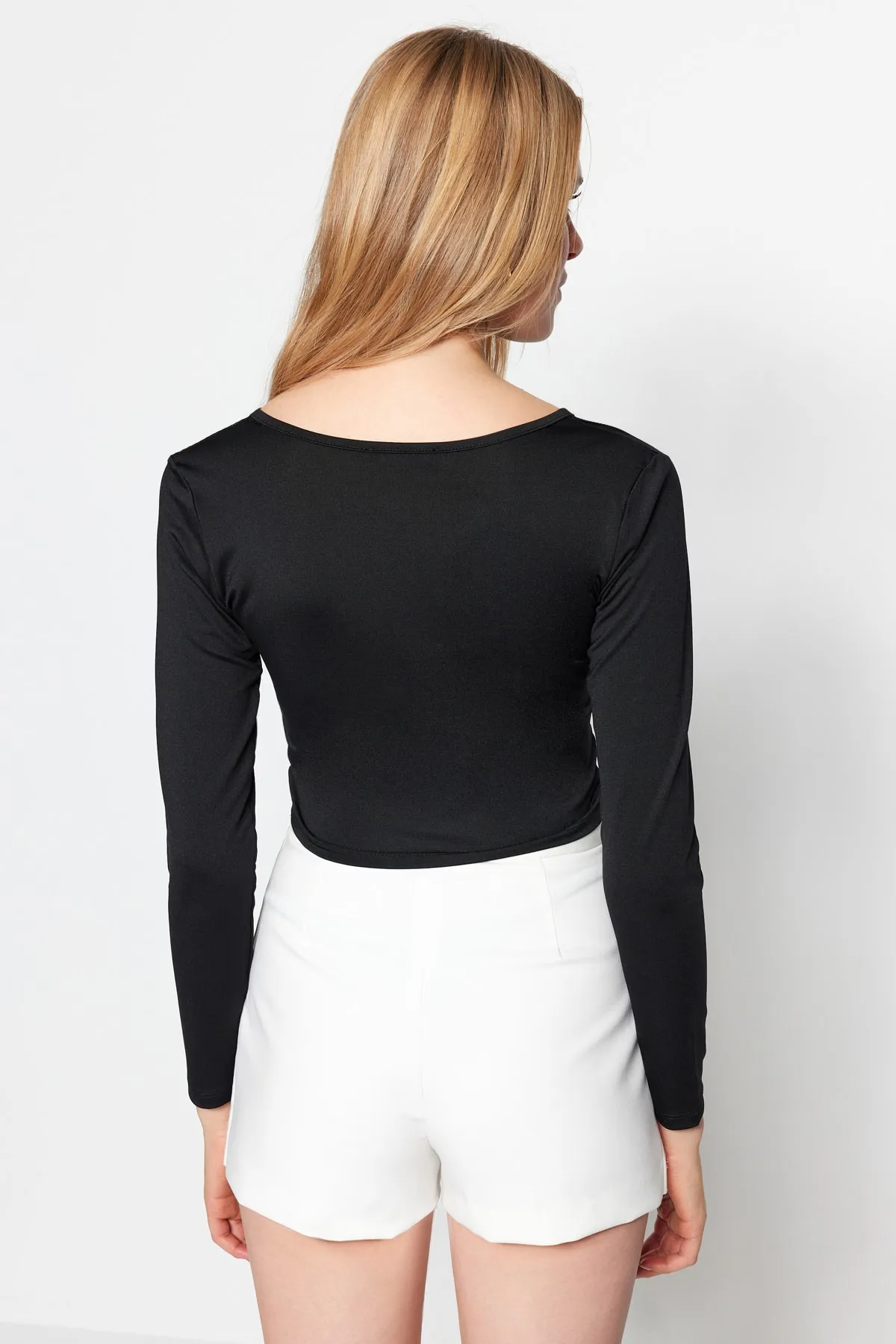 Trendyol Collection  Schwarze, eng anliegende, kurze Strickbluse mit V-Ausschnitt und Cut-Outs TWOSS23BZ00383